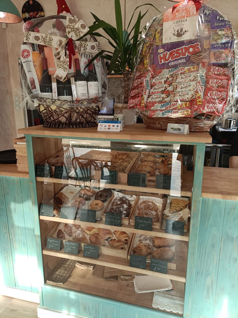 Vitrina de madera turquesa con croissants, ensaimadas y napolitanas