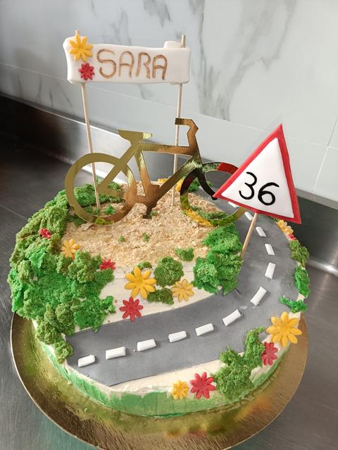 Tarta de cumpleaños con una ruta de montaña y una bici